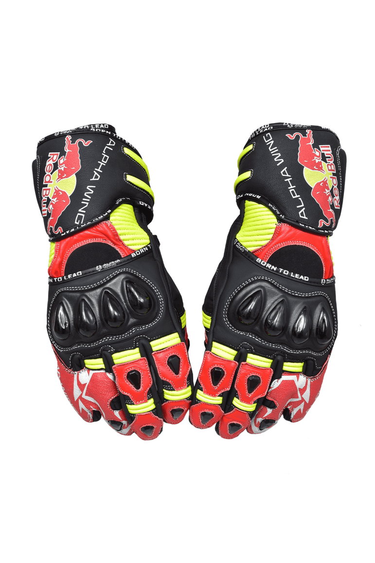 A pair of  Alpha Wing brand Red Bull Racing motorcycle gloves in black, red, and neon yellow, displayed against a plain white background.