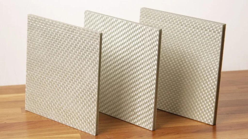 Three textured panels made of a light-colored, Kevlar Reinforced material stand upright on a wooden surface against a plain background.